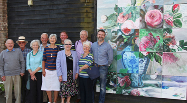 Artists gather next to the completed masterpiece outside Poundbury Gardens, taken by Neil Crick