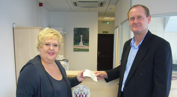 Pete Holden, chairman of the parish council, handing over the grant cheque to Mrs Ann Pogson, chairman of the memorial hall.