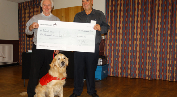 Andy (left) receives the cheque from BPPC chairman Gary Baker with Bubba in foreground
