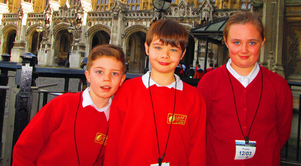 Three Elm Academy children stand in front of the Houses of Parliament, from left to right: Brendan Waters, Robert Stanners and Madison Croft Parliament.