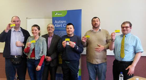 Members of Bournemouth Drop In Group receive the first Autism Alert Cards for Bournemouth, Dorset & Poole from Bob Lowndes, Chief Executive of Autism Wessex