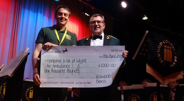 Philip Reeves of the Hampshire & Isle of Wight Air Ambulance Service receiving a donation of £1,000 from Verwood Concert Brass band member Robin Lock.