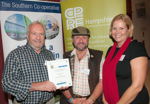 Pondhead Conservation Trust volunteers Derek Tippetts and Dave Dibden are presented with their Community and Voluntary award, presented by Gemma Lacey from The Southern Co-operative