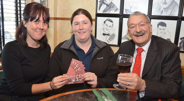 (From left) Natalie Doody presents vouchers winner Carly Reeves with Peter Matthews