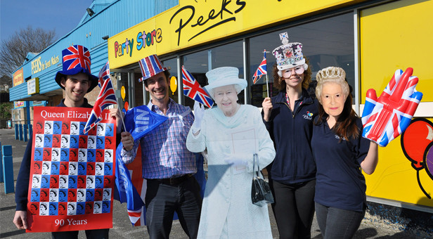 Nick Peek next to the cut-out of The Queen and some of Peeks' staff