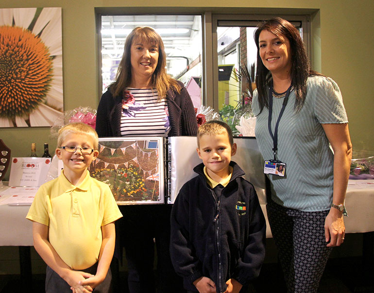 Ferndown First pupils Harry and Tyler with teaching assistant Mrs Maylin (holding book) and teacher Miss Ware