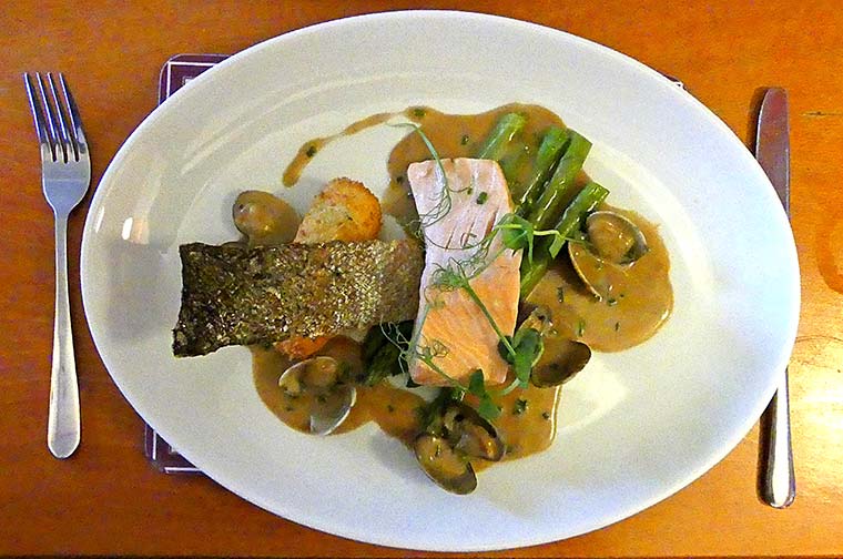 Poached salmon fillet with crispy skin, asparagus, and lemon potato croquette