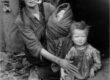 A Traveller woman smoking a clay pipe with her two children in the 1910s © Dorset History Centre