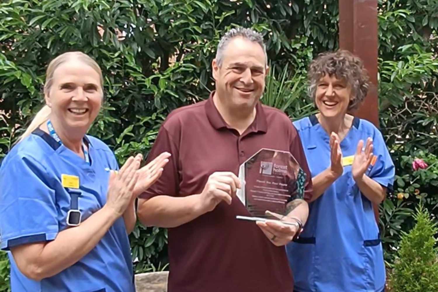 Paul Payne with Forest Holme Hospice nurses receiving his presentation plaque
