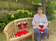 Museum volunteer Sally Palmer with some of the knitted poppies and Remembrance Teddies.